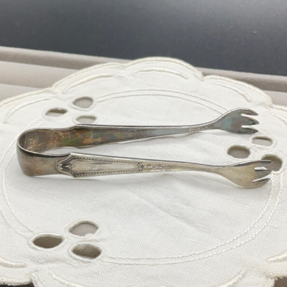 JS Co. Sterling sugar tongs.